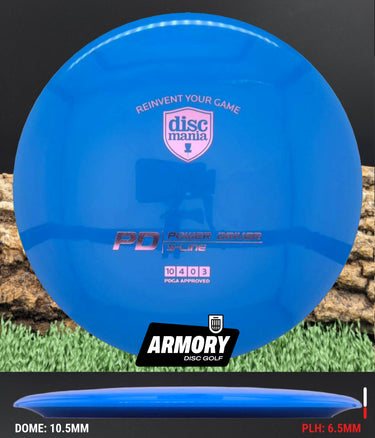 Blue disc golf disc with Discmania and Armory Disc Golf branding on a grass and log background.